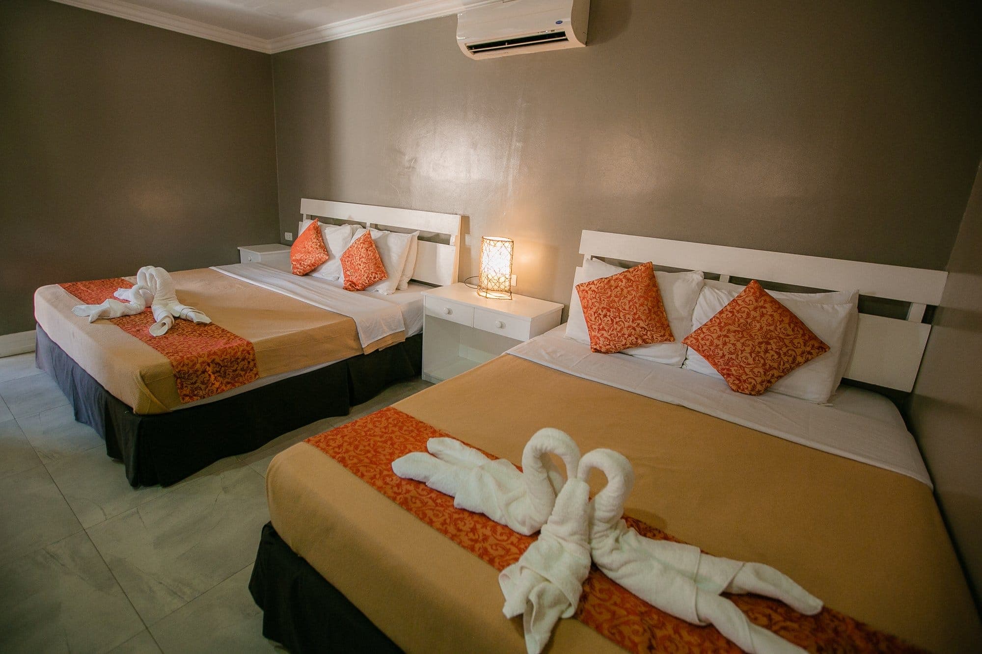 Family Room with a king and a queen bed dressed in warm gold