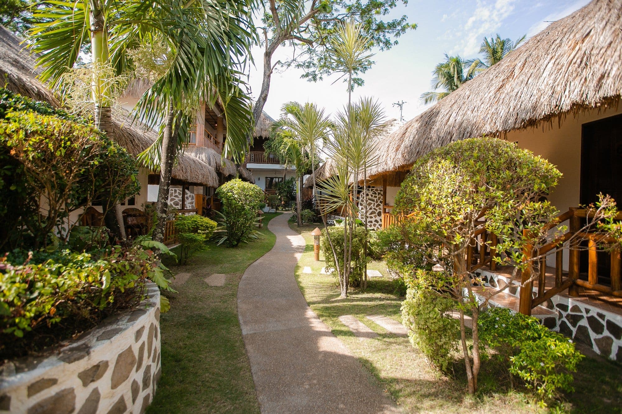 Garden path between thatched bungalows at Kav's Beach Resort